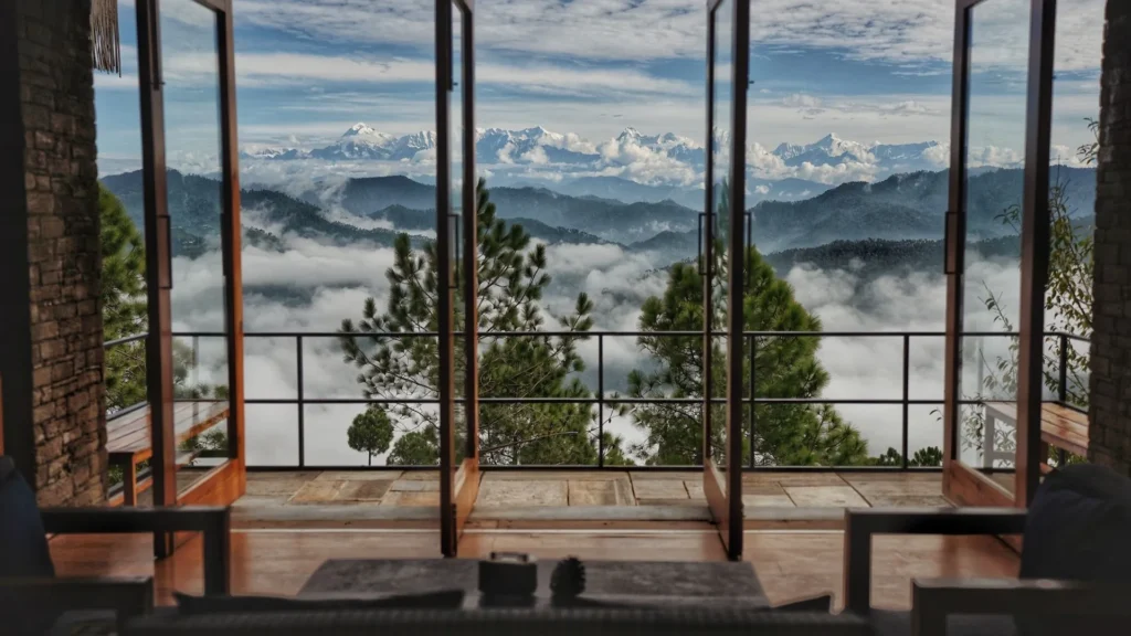 Rolling green tea plantations in Darjeeling under a misty morning sky.